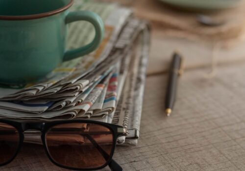 Newspapers and coffee cups on wooden boards.